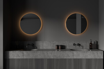 Dark bathroom interior with sink and mirror, accessories on deck
