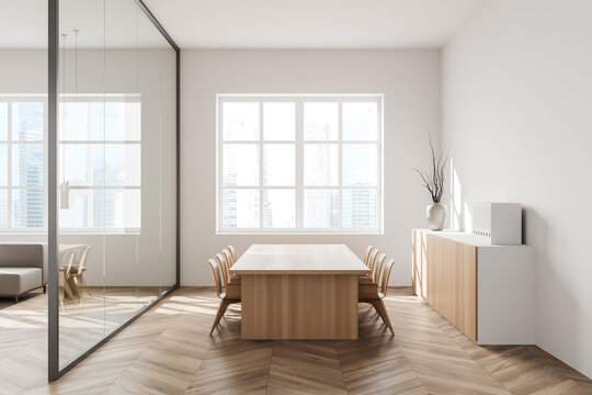 Light meeting interior with seats, table and commode near panoramic window