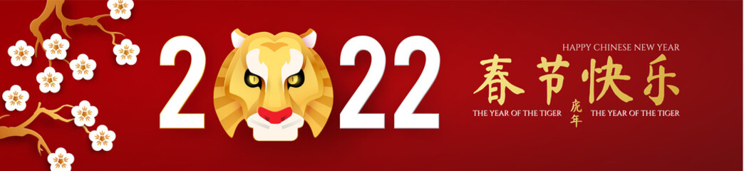 Happy Chinese New Year, 2022 the year of the Tiger. Papercut design with tiger head character, cherry blossom and flowers. Chinese text means The year of the Tiger.