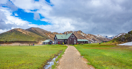 Surreal magic Icelandic landscape of colorful rainbow volcanic Landmannalaugar mountains, and a biggest camping site there with tourists and hikers, Iceland, summer.