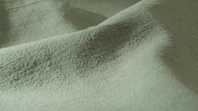 Green olive fabric close-up, light khaki cloth texture background. Macro shooting of cotton textile. 
