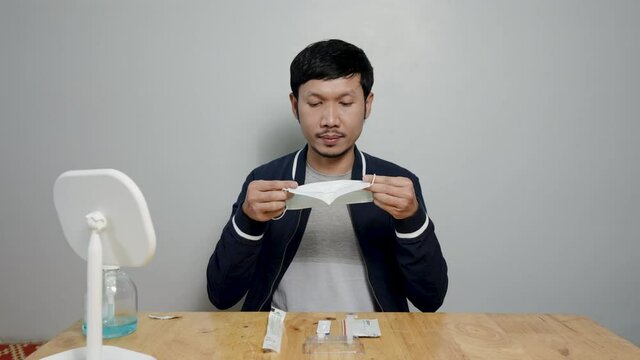 Asian man uses rapid antigen test kit to detect COVID-19 by yourself at home Preparing to test the infection of the virus will prevent the spread of the virus itself.