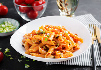 Classic italian pasta penne marinara with mussels and green onions on dark table. Penne pasta with sauce marinara.