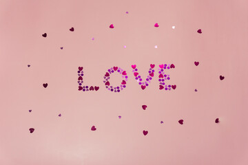 Word love from small hearts on a pink background. Valentine's day concept