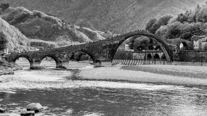 Black and white view of river Serchio that flows under the Ponte della Maddalena or del Diavolo,...