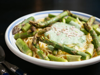 Green asparagus on spaghetti with a wild garlic sauce.