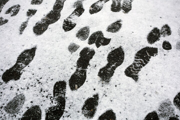 Shoe marks on the snowy asphalt