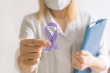 International Epilepsy Day. Doctor in coat holds purple ribbon on white background. Alzheimer's...