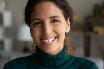 Obraz premium Close up head shot sincere happy millennial generation woman looking at camera. Joyful female client with white toothy smile and perfect skin feeling satisfied with dentistry or cosmetology service.