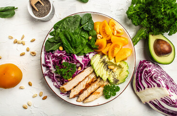 Plate with a keto diet food with chicken fillet, purple cabbage, avocado, spinach, tomatoes and nuts. Detox and healthy concept. Keto paleo lunch