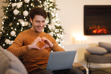 Man having video call showing heart gesture