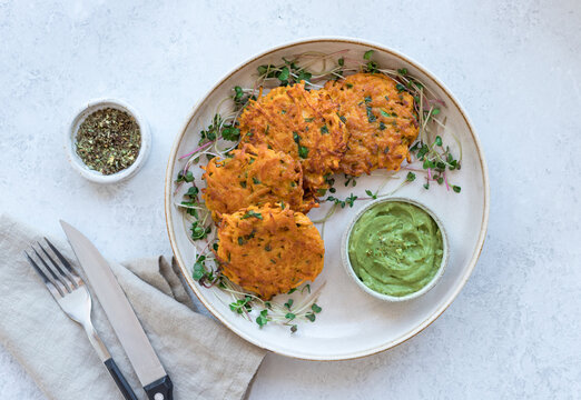 sweet potato fritters with creamy avocado dip on ceramic plate. Healthy vegan food concept. top view