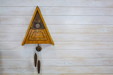 Vintage wooden clock on a light wooden background
