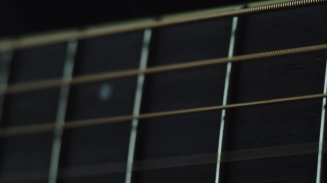 The musician plays the acoustic guitar. Closeup of the right hand. Macro shooting. Depth of field