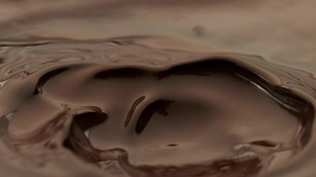 Super slow motion of flowing dark hot chocolate splashes. Filmed with high speed cinema camera, 1000fps.