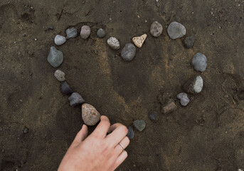 Making a heart on the beach with stones.
