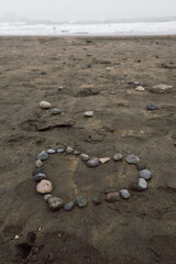 Making a heart on the beach with stones.