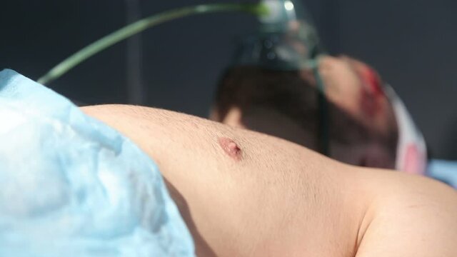 Close up of professional doctor in operating room trying to help on intensive care patient, making cpr to shock heart