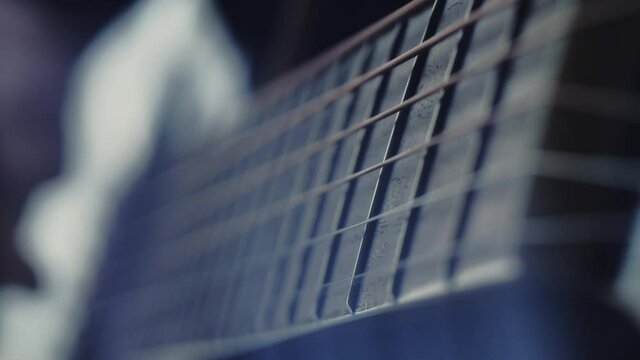The musician plays the acoustic guitar. Closeup of the right hand. Macro shooting. Depth of field