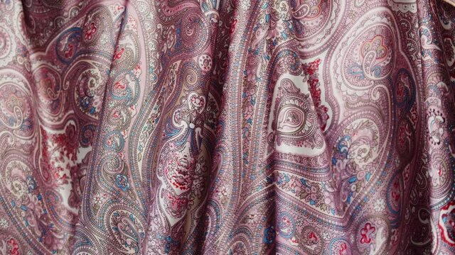 Pink silk fabric close-up, arabian design or indian pattern. Cloth texture background. Macro shooting of textile.