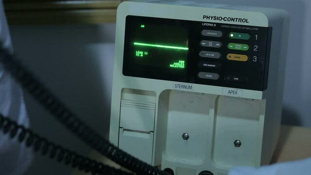 Doctor give resuscitation to a patient in the emergency room. Cardiac massage. Defibrillation. The professional life-saving device in the hospital. First aid