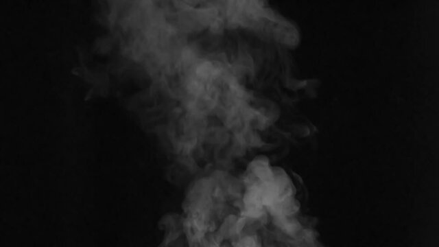 Hot Steam Rushes Upwards. Light warm water vapor slowly rises above the tea mug and quickly disappears against a black background