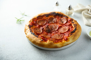 Traditional pepperoni pizza on the wooden desk