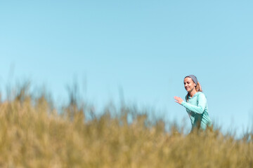 Young active woman jogging in the field in the countryside