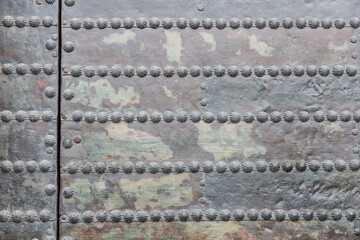 Old wooden door covered with metal