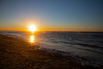 Sunset over the ocean at the beach - obrazy, fototapety, plakaty