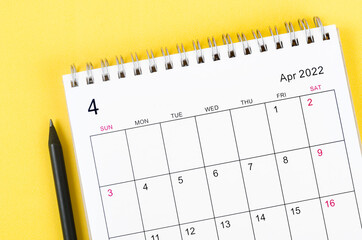 April 2022 desk calendar on yellow background.