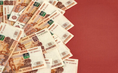 Russian money lies on a red background. Place to copy.