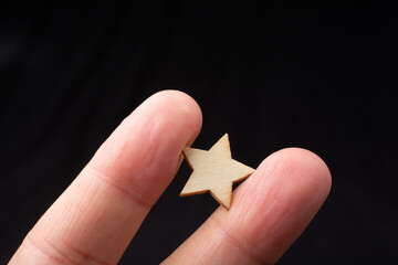 Hand hold wooden star sign. Product service evaluation concept