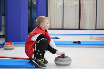 boy playing curling in a sports club