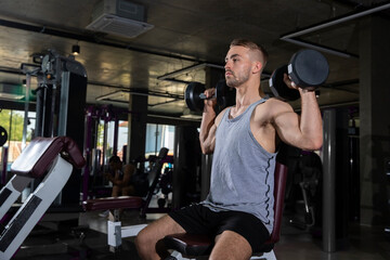 Handsome Athletic Men Exercising with dumbbells in modern gym. Fitness  men with naked torso doing workout . healthy concept