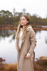 Lifestyle photo A girl trench coat in nature.  viru bog trail in Estonia. Travel,  exploration,...