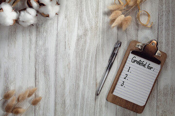 Grateful for text list on notepad with rustic wooden gray flat lay background and natural elements....