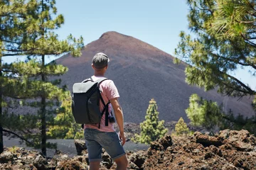 Photo sur Plexiglas les îles Canaries Traveler walking against volcanic landscape. Man with backpack looking on Chinyero Volcano. Tenerife, Canary Islands, Spain..