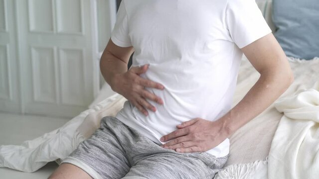 Stomach ache, man with abdominal pain suffering at home, health problems concept