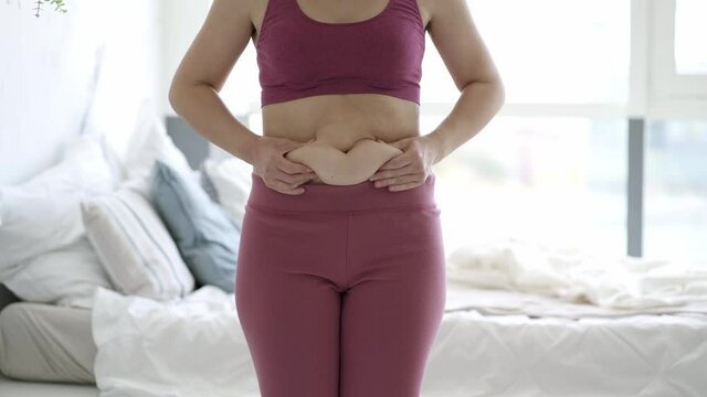 Abdominal massage, tummy tuck and flabby skin on a fat belly, woman doing self-massage, plastic surgery concept