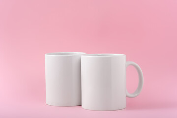 Mockup two white coffe cup or mug on a pink background with copy space. Blank template for your design, branding, business. Real photo