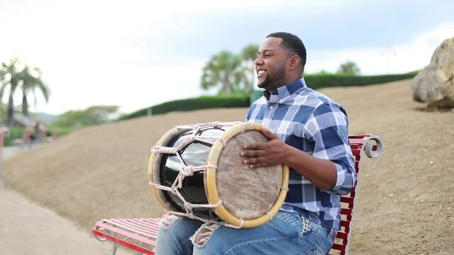 young dominican man playing tambora merengue