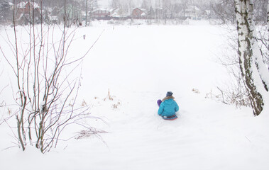 girl rides on a hill in winter