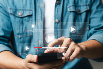 Online movie streaming with smartphone. Young man watching a movie on a mobile phone with an...