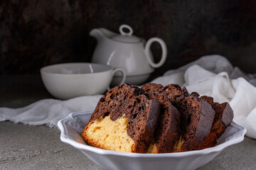 cake pieces from light and dark dough in a white ceramic plate, close up