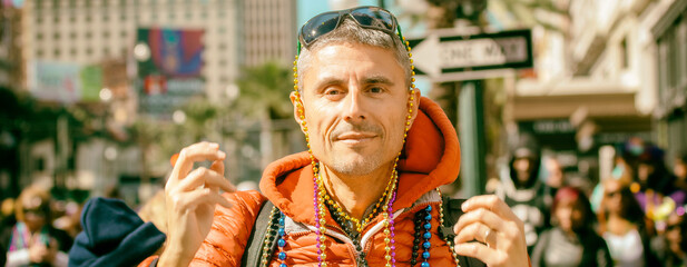 Happy man with colorful beads at Mardi Gras carnival parade event.