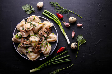 Dumplings with mushrooms on a black background with onions, garlic and eggs