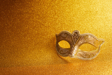 Carnival mask on a glitter golden background