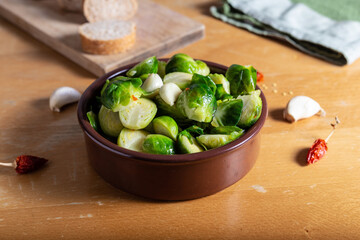 Brusselle spout with garlic on a wooden background.