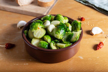 Brusselle spout with garlic on a wooden background.